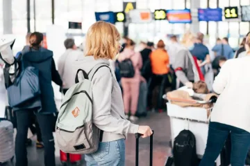 Planejando a viagem: passageira consultando aguardando para fazer check-in aéreo