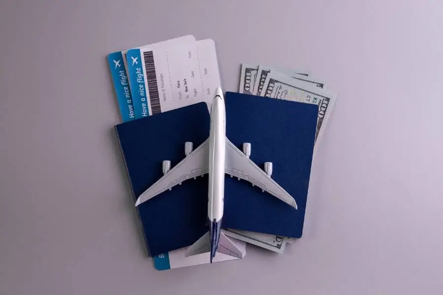 Avião de brinquedo sobre passaportes, dólares e cartões de embarque para viagem