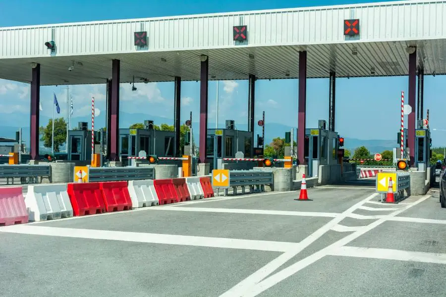 Praça de pedágio em rodovia com cabines de cobrança.