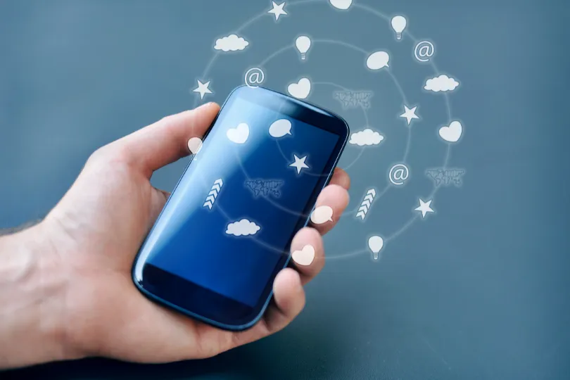 Imagem de um telefone com um holograma projetado acima, mostrando ícones de aplicativos.